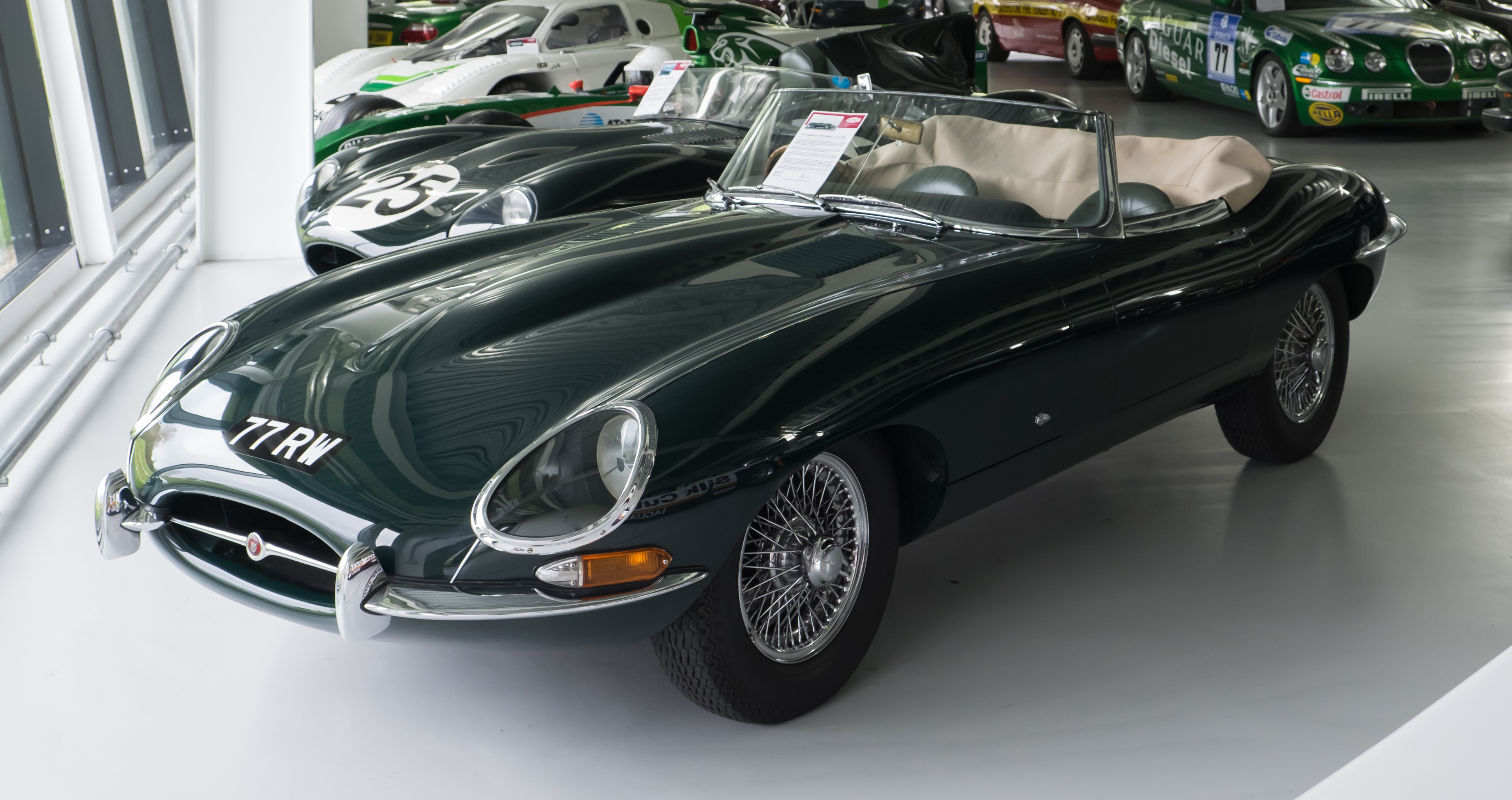 1961 Jaguar E-Type in British Racing Green on a country road, long bonnet and wire wheels
